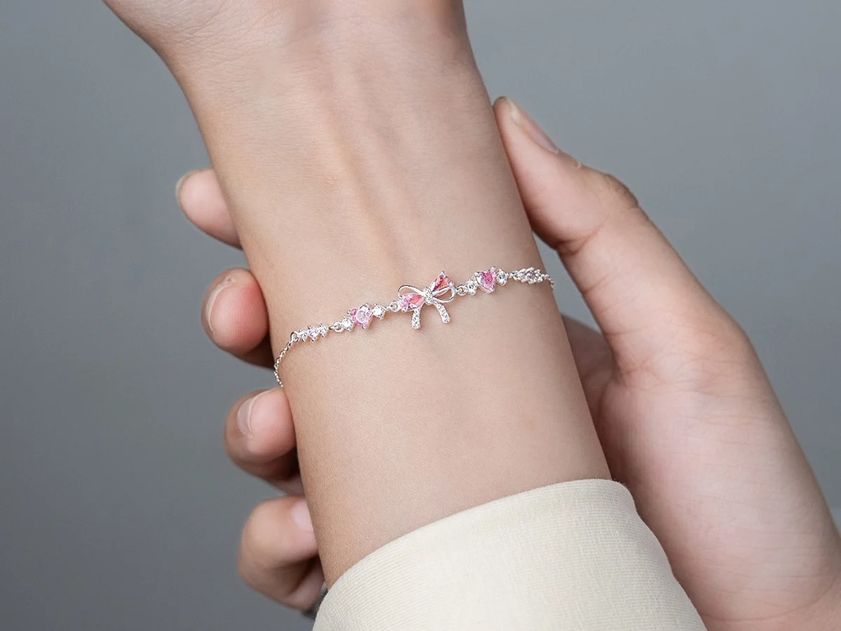 Lắc tay bạc nữ nơ hồng Daisy Róse LT43 đeo trên cổ tay — mẫu nơ 389.000đ của Asimi
