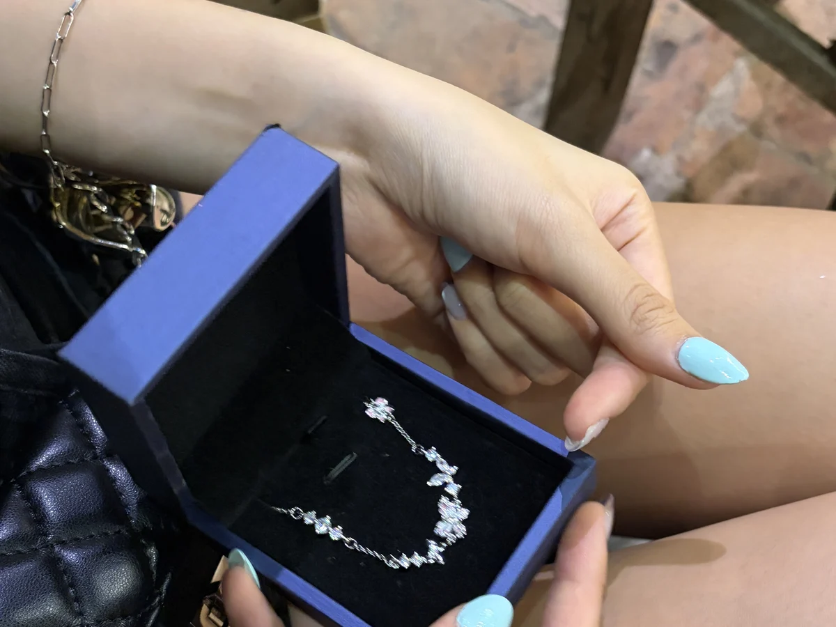 Nàng cầm hộp quà Asimi vừa mở với chiếc lắc tay bạc đính đá — khoảnh khắc trước khi đọc tấm thiệp viết tay tặng kèm