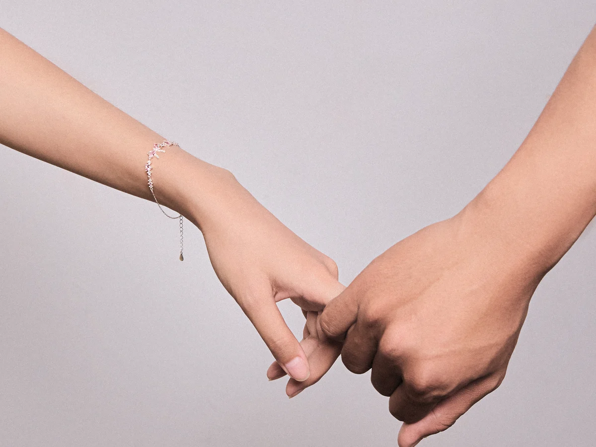 Hai bàn tay móc ngoặc, cổ tay đeo lắc tay bạc Asimi, minh hoạ chọn quà cho bạn gái theo gu