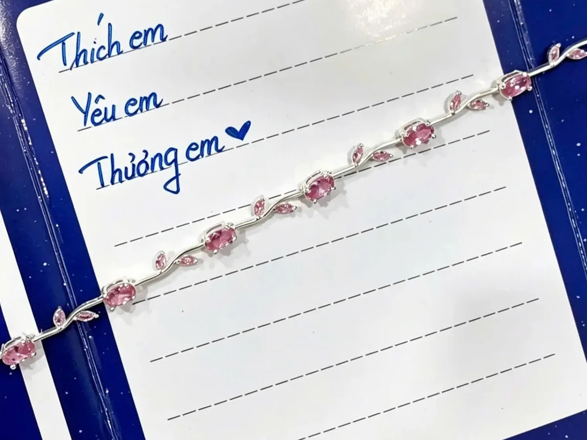 Tấm thiệp viết tay đặt cạnh chiếc lắc tay bạc — cách cá nhân hoá quà tặng bạn gái mới quen