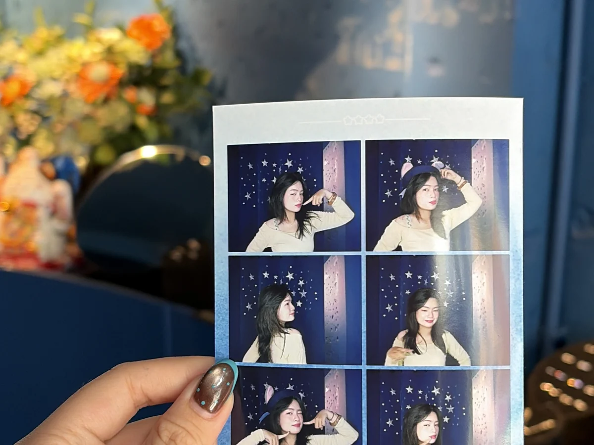 Cầm dải ảnh photobooth ASIMI tại cửa hàng — trải nghiệm viết thiệp tay tặng người yêu